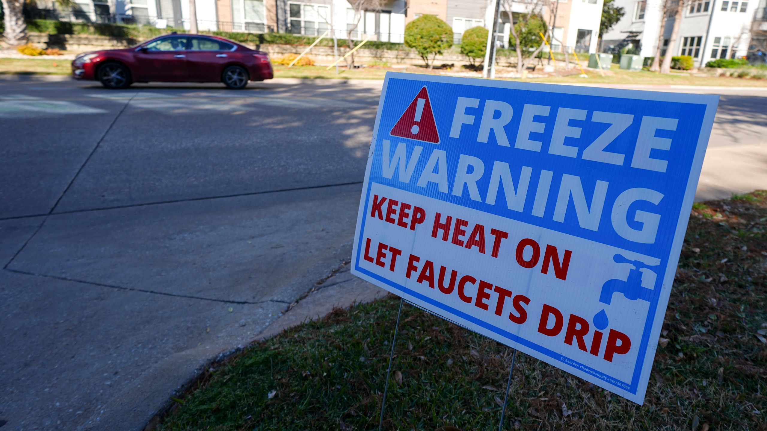 A freeze warning sign is stands outside of an apartment complex ahead of a winter storm expected to hit the North Texas region, Tuesday, Jan. 7, 2025, in Dallas. (AP Photo/Julio Cortez)