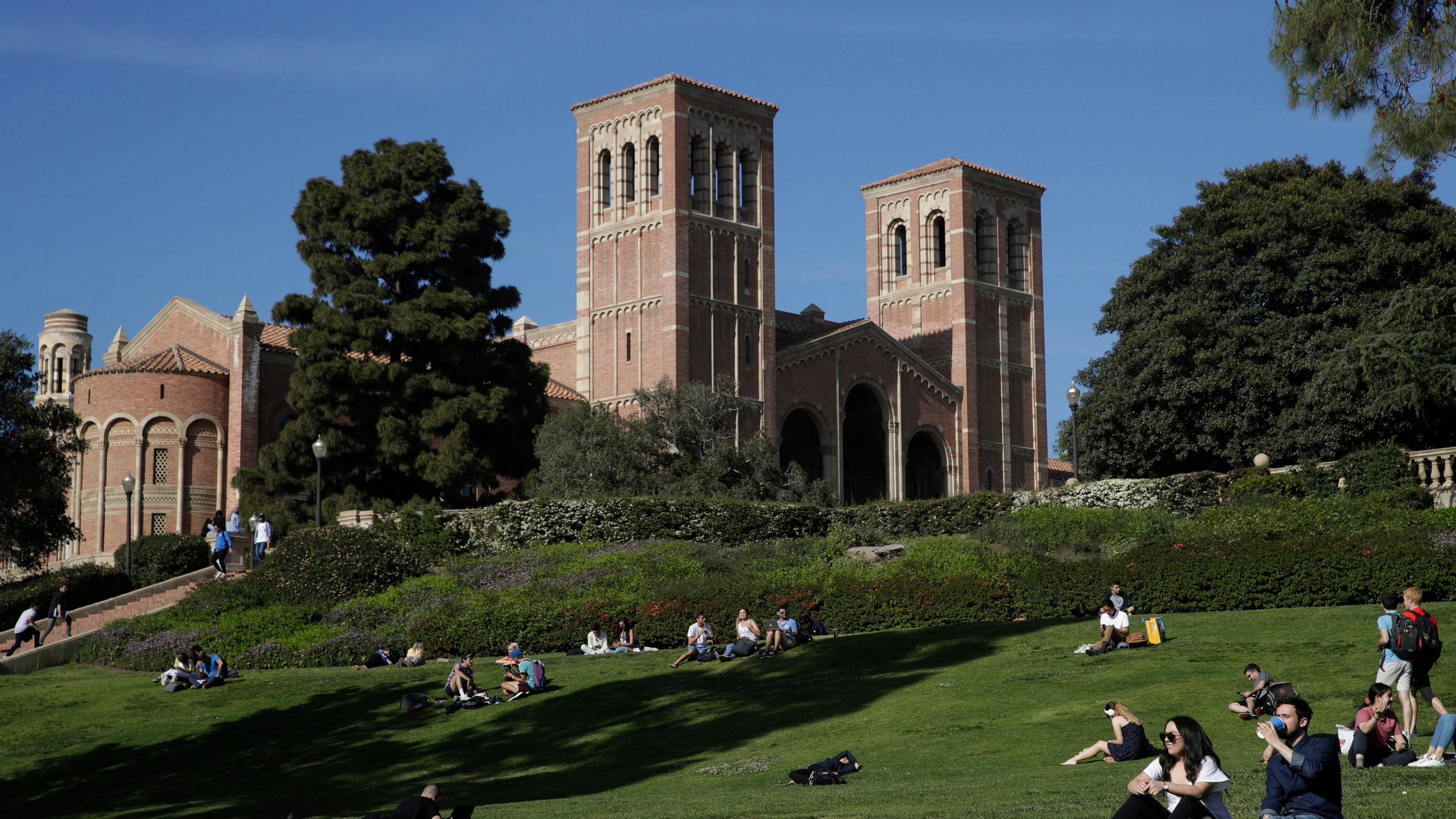 FILE - Students sit on the lawn near Royce Hall at the University of California, Los Angeles, in the Westwood section of Los Angeles on April 25, 2019. (AP Photo/Jae C. Hong, File)