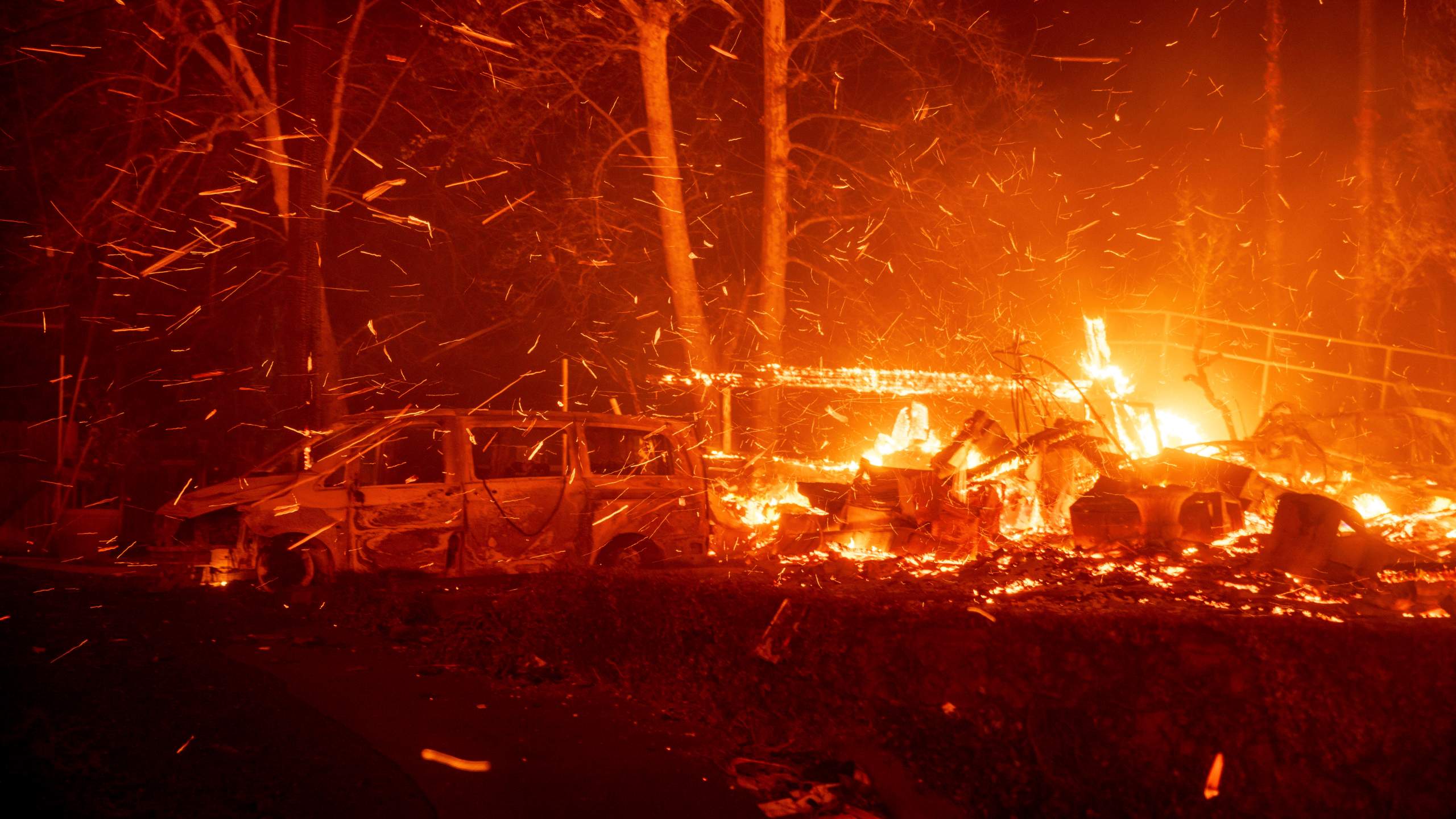 The Eaton Fire burns vehicles and structures Wednesday, Jan. 8, 2025 in Altadena, Calif. (AP Photo/Ethan Swope)