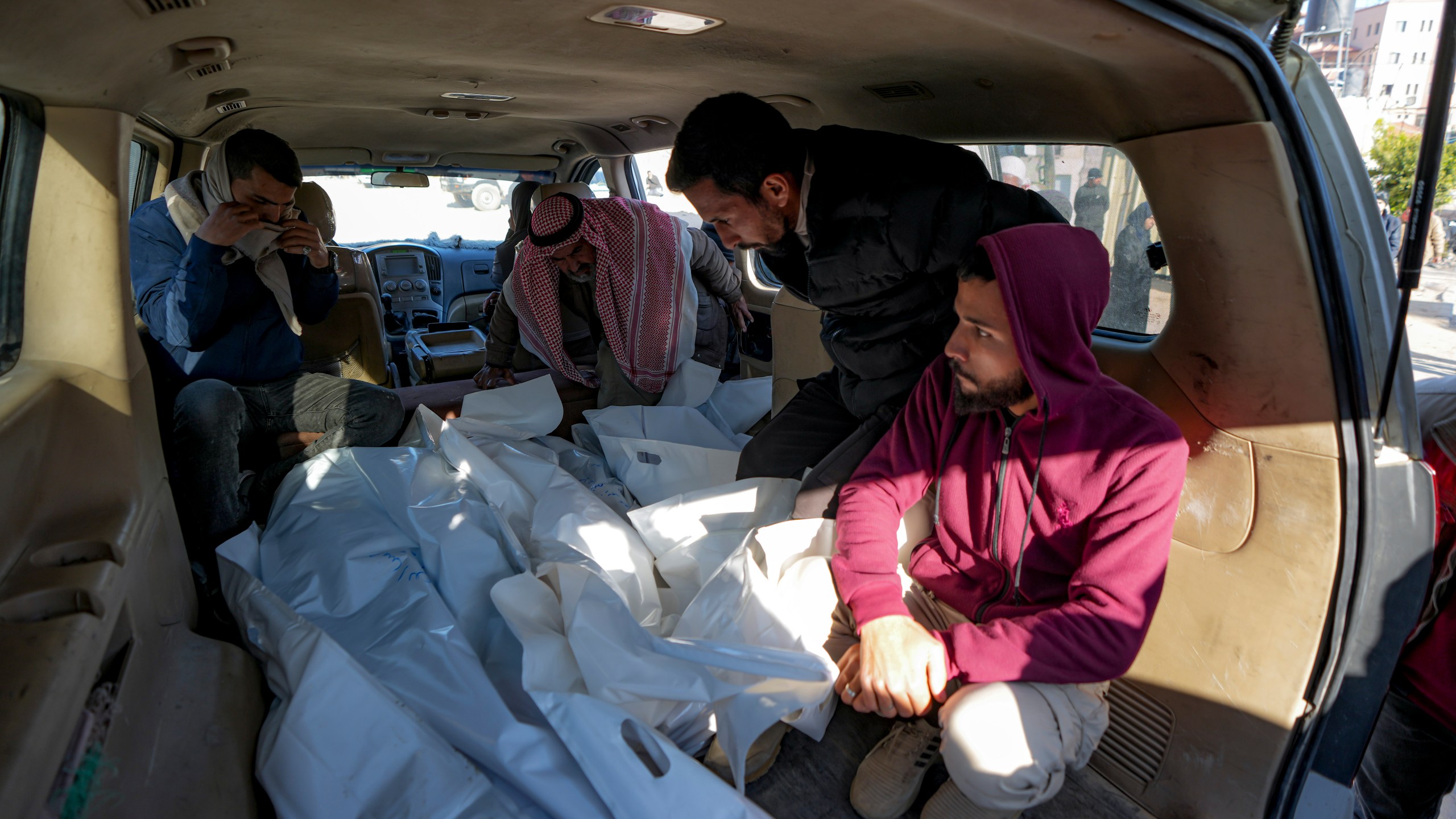 Mourners transport the bodies of their relatives killed in the Israeli bombardment of the Gaza Strip, during their funeral in Deir al-Balah, Wednesday, Jan. 8, 2025. (AP Photo/Abdel Kareem Hana)