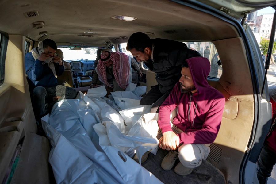 Mourners transport the bodies of their relatives killed in the Israeli bombardment of the Gaza Strip, during their funeral in Deir al-Balah, Wednesday, Jan. 8, 2025. (AP Photo/Abdel Kareem Hana)