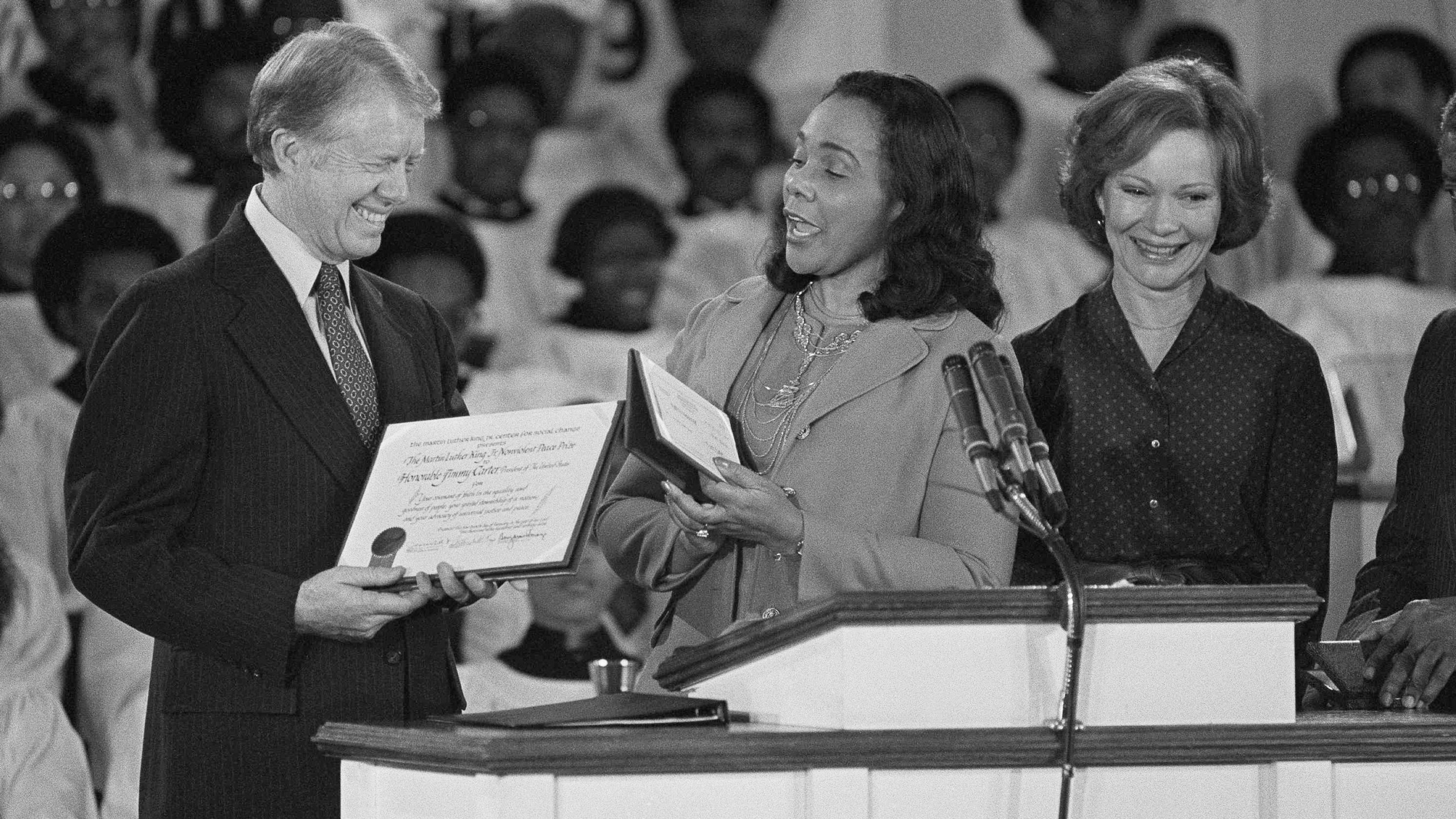 FILE - Coretta Scott King, center, widow of Martin Luther King Jr., presents the Martin Luther King Jr. Nonviolent Peace Prize to President Jimmy Carter at the Ebenezer Baptist Church on Jan. 14, 1979, in Atlanta. First lady Rosalynn Carter stands with them at the podium. (AP Photo/Jim Wells, File)