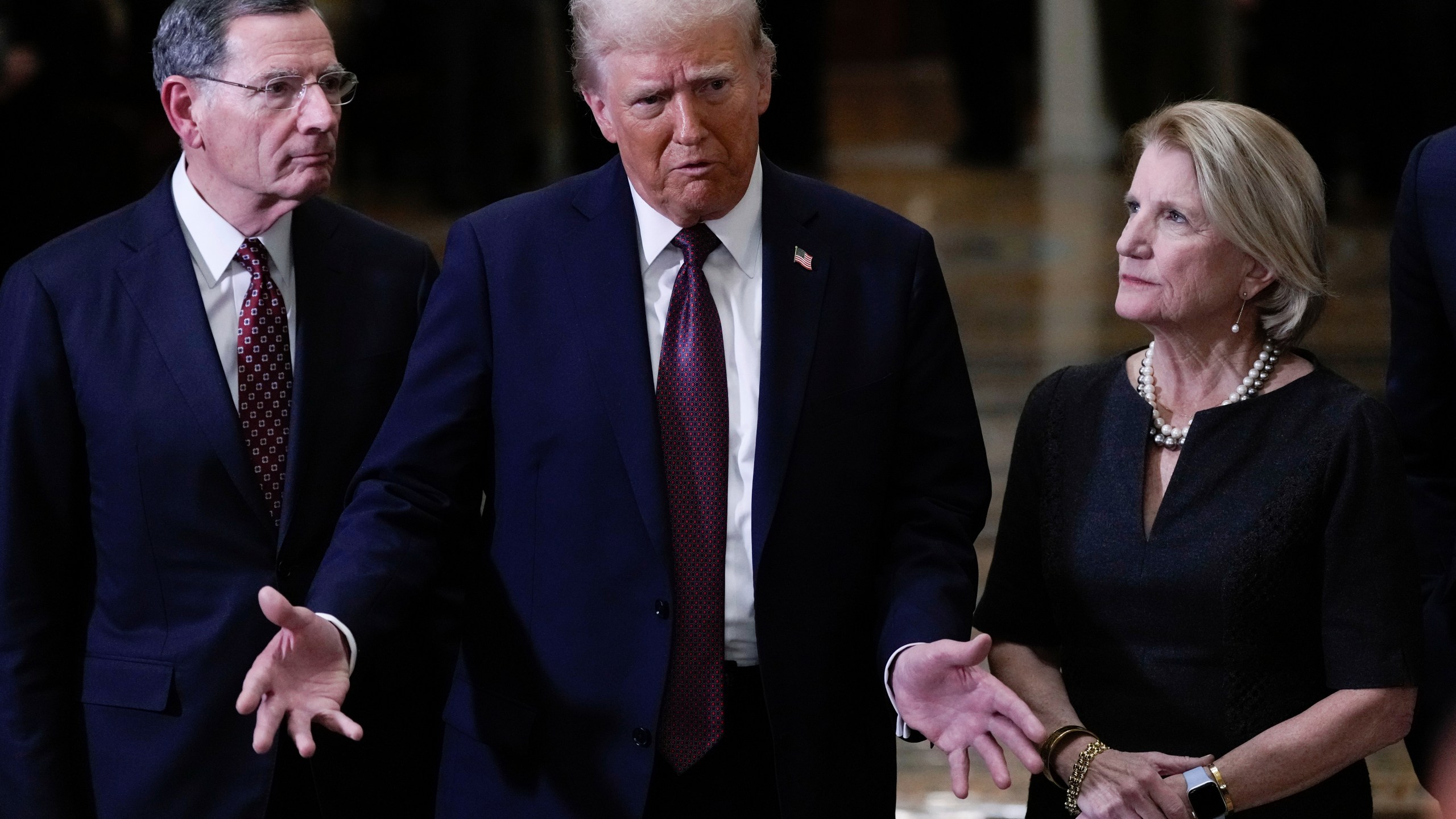 President-elect Donald Trump, flanked by Sen. John Barrasso, R-Wyo., left, and Sen. Shelley Moore Capito, R-W.Va., talks to reporters after a meeting with Republican leadership at the Capitol on Wednesday, Jan. 8, 2025, in Washington. (AP Photo/Steve Helber)