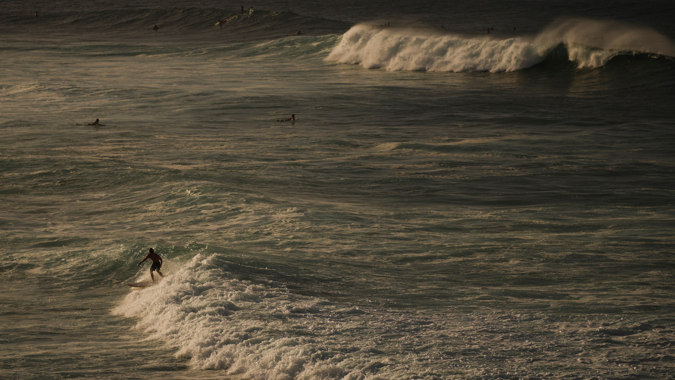 FILE - Surfers catch waves in the Pacific Ocean off of Ho'okipa Beach Park, Nov. 22, 2024, near Paia, Hawaii. (AP Photo/Lindsey Wasson, File)