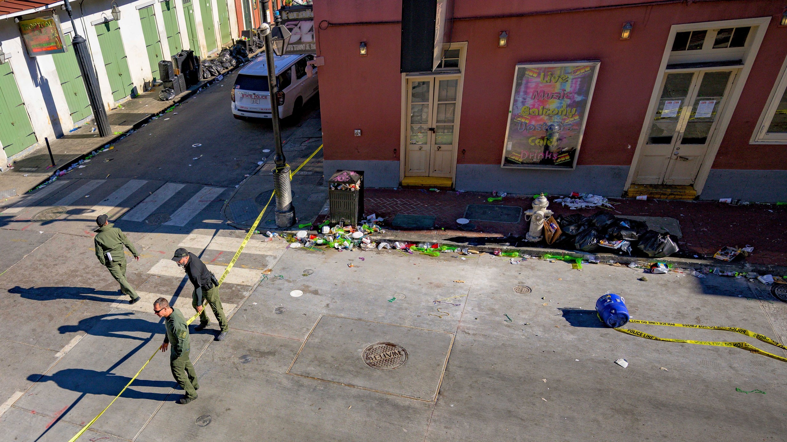 Members of the FBI and bomb squad detonated a suspicious package from the blue cooler, bottom right, damaging a doorway according to an eyewitness at Bourbon Street near Toulouse Street during the investigation of truck crashing into pedestrians on Bourbon Street in the French Quarter in New Orleans, Wednesday, Jan. 1, 2025. (AP Photo/Matthew Hinton)