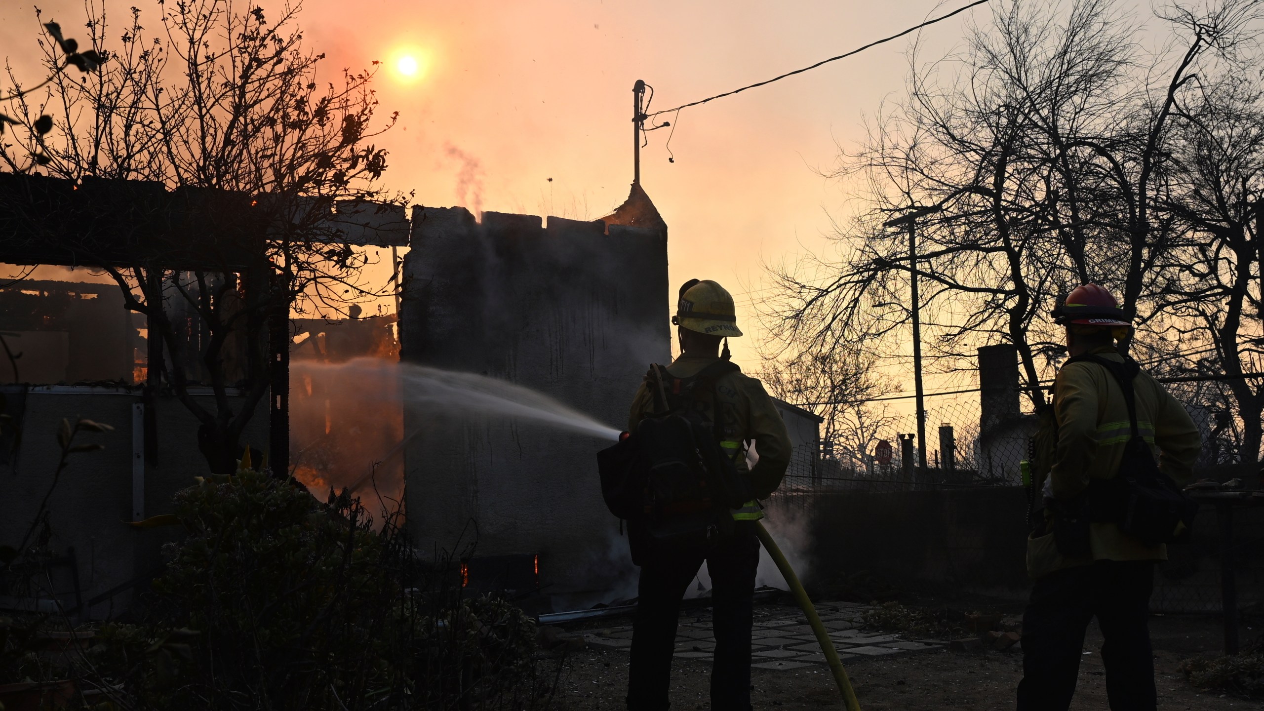 Firefighters water down a home after the Eaton Fire burns in Altadena, Calif., Thursday, Jan. 9, 2025. (AP Photo/Nic Coury)