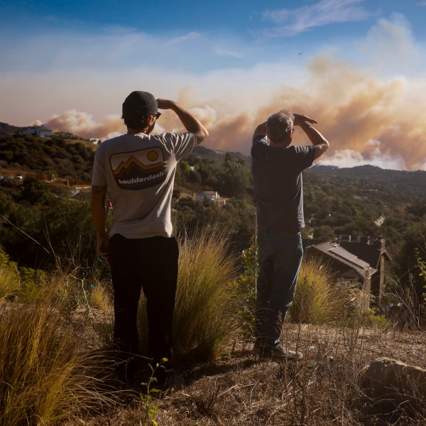 Topanga Canyon inhabitants look on as the Palisades Fire burns in the hills between Pacific Palisades and Malibu Wednesday, Jan. 8, 2025 in Topanga, Calif. (AP Photo/Etienne Laurent)