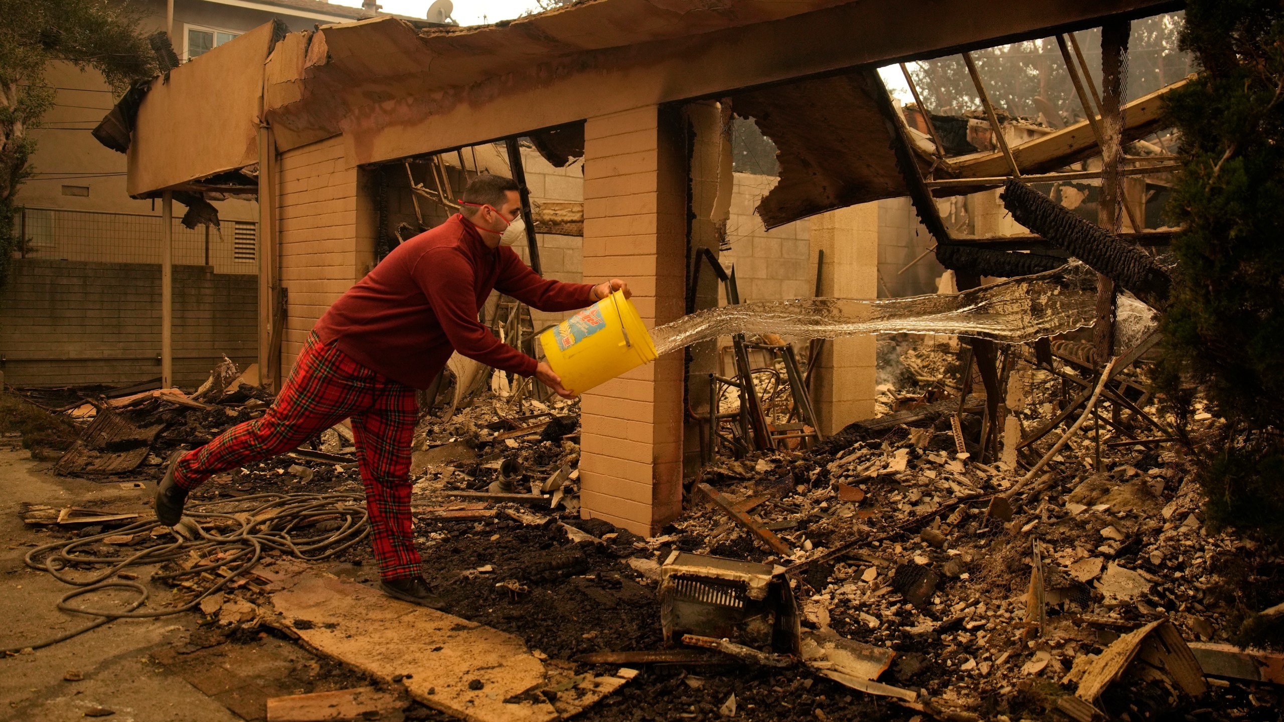 Shane Torre douses hot spots of what remains of his home In Altadena, Calif., Thursday, Jan. 9, 2025. (AP Photo/John Locher)