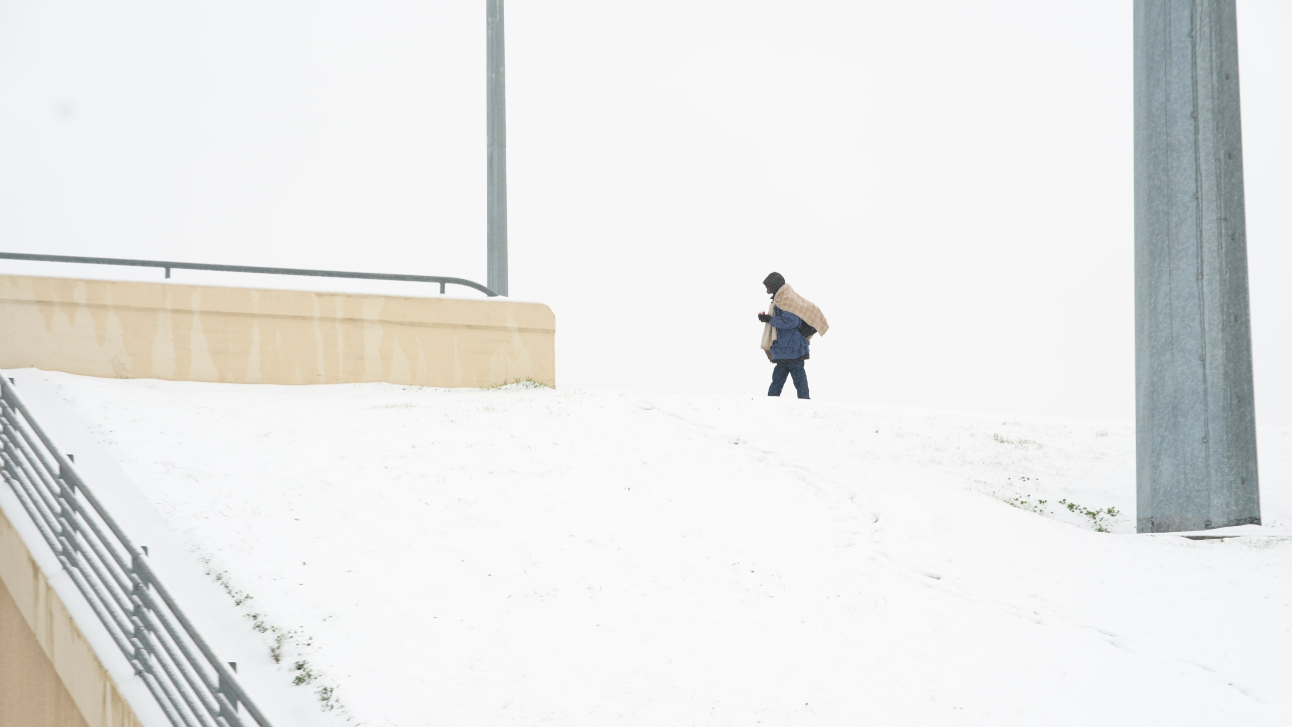 Frank Burnett walks on a snow covered overpass Thursday, Jan. 9, 2025, in Plano, Texas. (AP Photo/LM Otero)