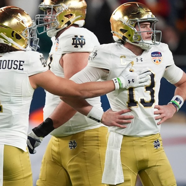 Notre Dame wide receiver Jaden Greathouse (1) reaches out to quarterback Riley Leonard (13) after he was sacked during the first half of the Orange Bowl NCAA College Football Playoff semifinal game against Penn State, Thursday, Jan. 9, 2025, in Miami Gardens, Fla. (AP Photo/Rebecca Blackwell)