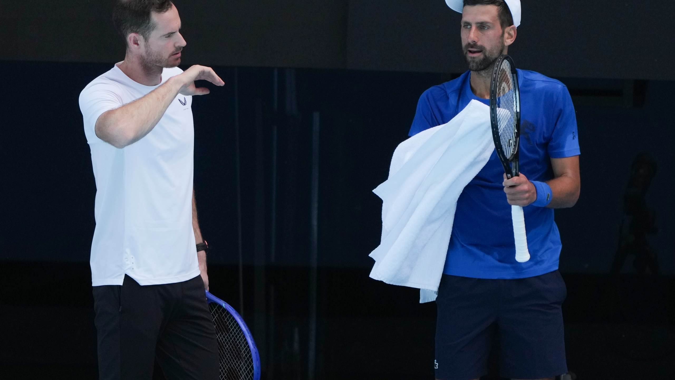 Serbia's Novak Djokovic talks with his coach Andy Murray, left, during a practice session ahead of the Australian Open tennis championship in Melbourne, Australia, Thursday, Jan. 9, 2025. (AP Photo/Mark Baker)