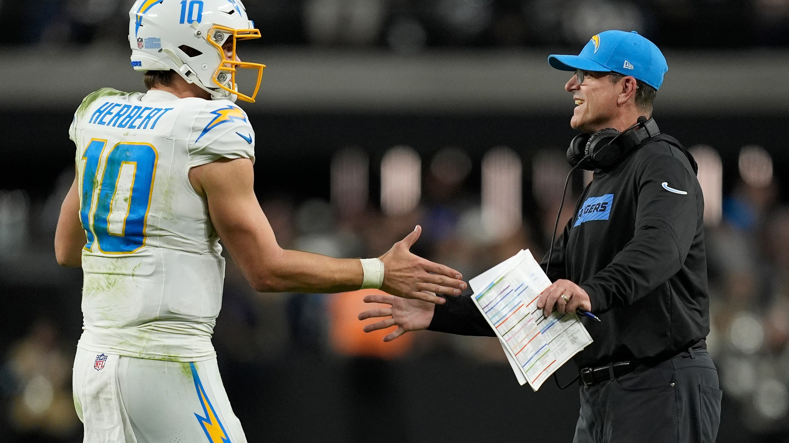 Los Angeles Chargers quarterback Justin Herbert (10) celebrates with head coach Jim Harbaugh during the second half of an NFL football game against the Las Vegas Raiders in Las Vegas, Sunday, Jan. 5, 2025. (AP Photo/John Locher)