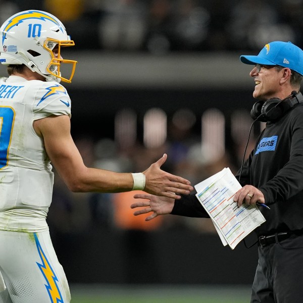 Los Angeles Chargers quarterback Justin Herbert (10) celebrates with head coach Jim Harbaugh during the second half of an NFL football game against the Las Vegas Raiders in Las Vegas, Sunday, Jan. 5, 2025. (AP Photo/John Locher)