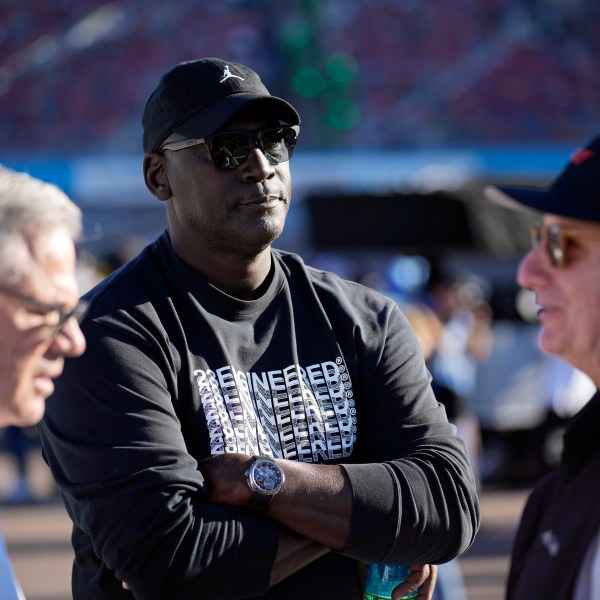 FILE - Michael Jordan, center, and Curtis Polk, left, co-owners of 23XI Racing, watch during qualifying beside 23XI Racing President Steve Lauletta, right, for a NASCAR Cup Series Championship auto race, Saturday, Nov. 9, 2024, in Avondale, Ariz. (AP Photo/John Locher, File)