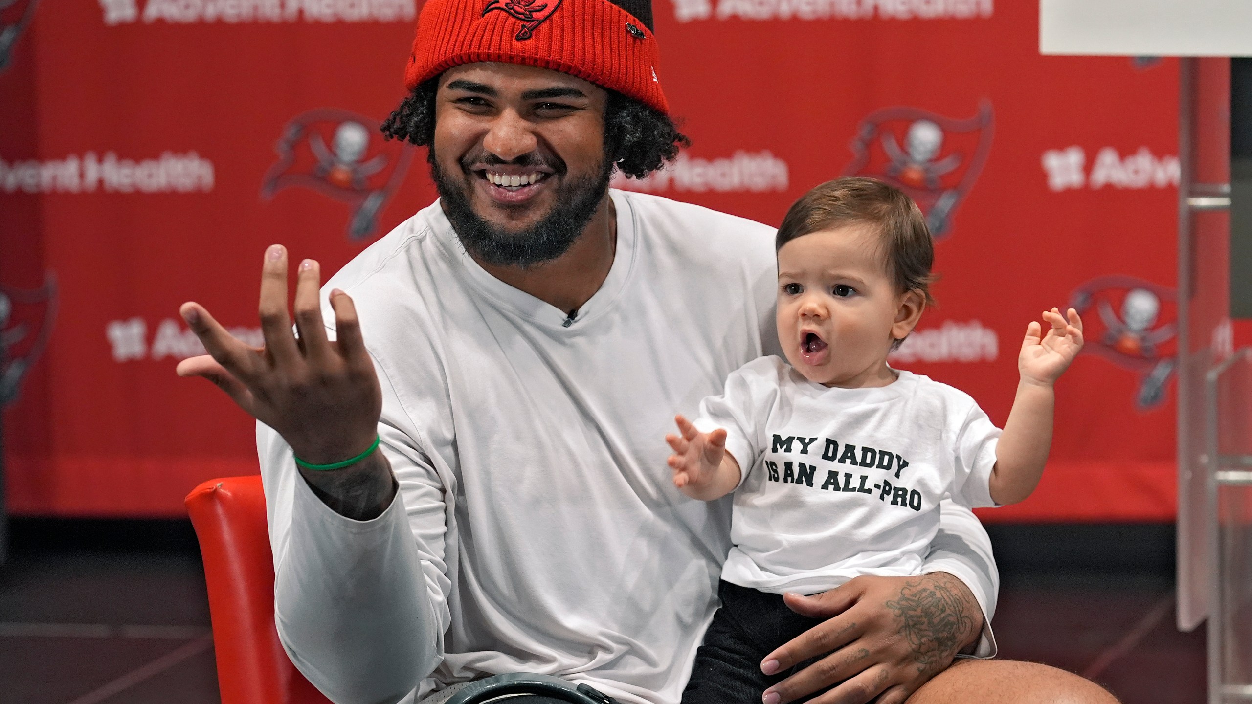 Tampa Bay Buccaneers offensive lineman Tristan Wirfs smiles as he holds his son Julius during an NFL football news conference Thursday, Jan. 9, 2025, in Tampa, Fla. Wirfs has been named to the AP All-Pro football team. (AP Photo/Chris O'Meara)