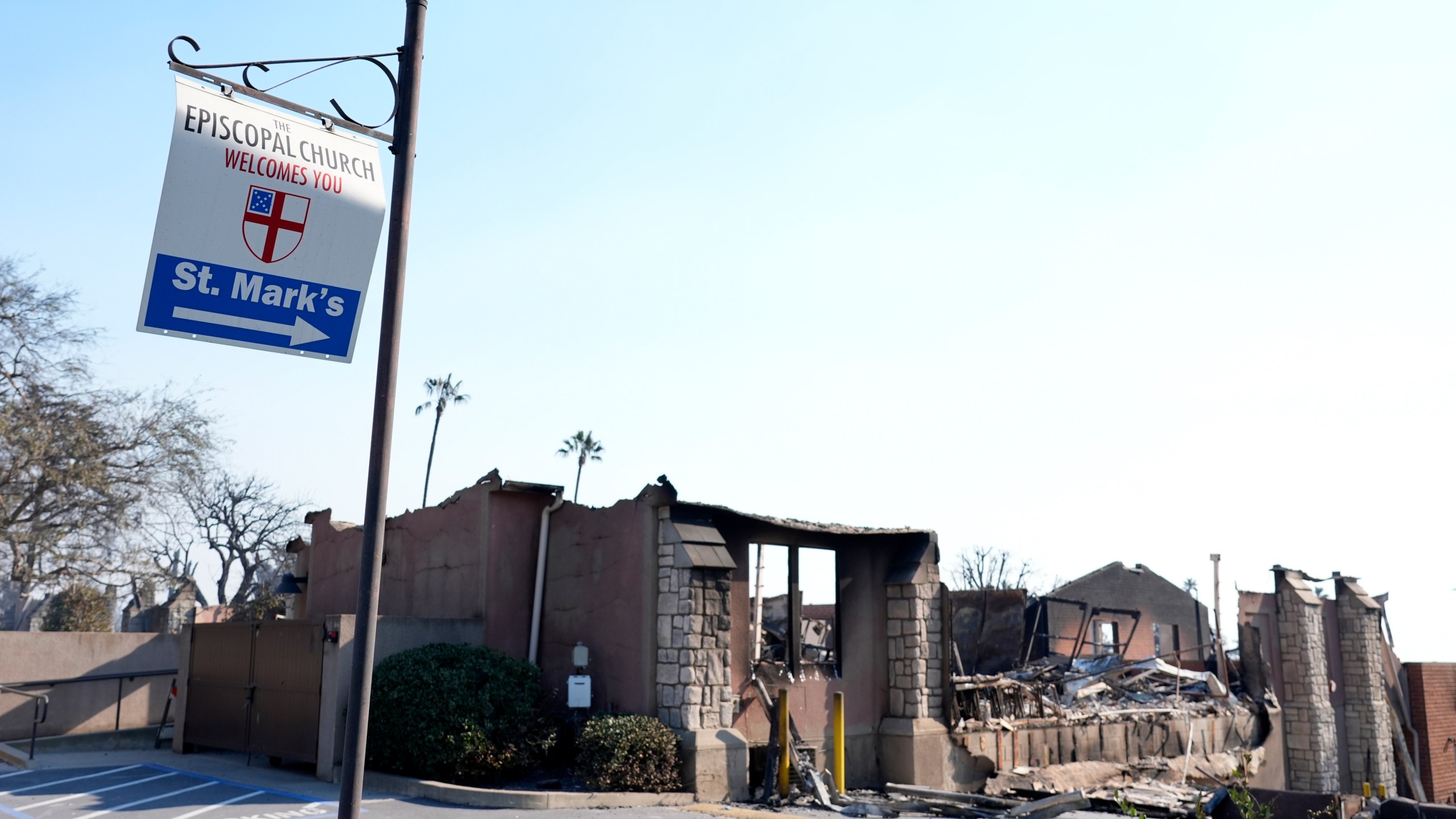 A welcome sign points to the charred remains of St. Mark's Episcopal Church after it was destroyed by the Eaton Fire, Friday, Jan. 10, 2025, in Altadena, Calif. (AP Photo/Chris Pizzello)