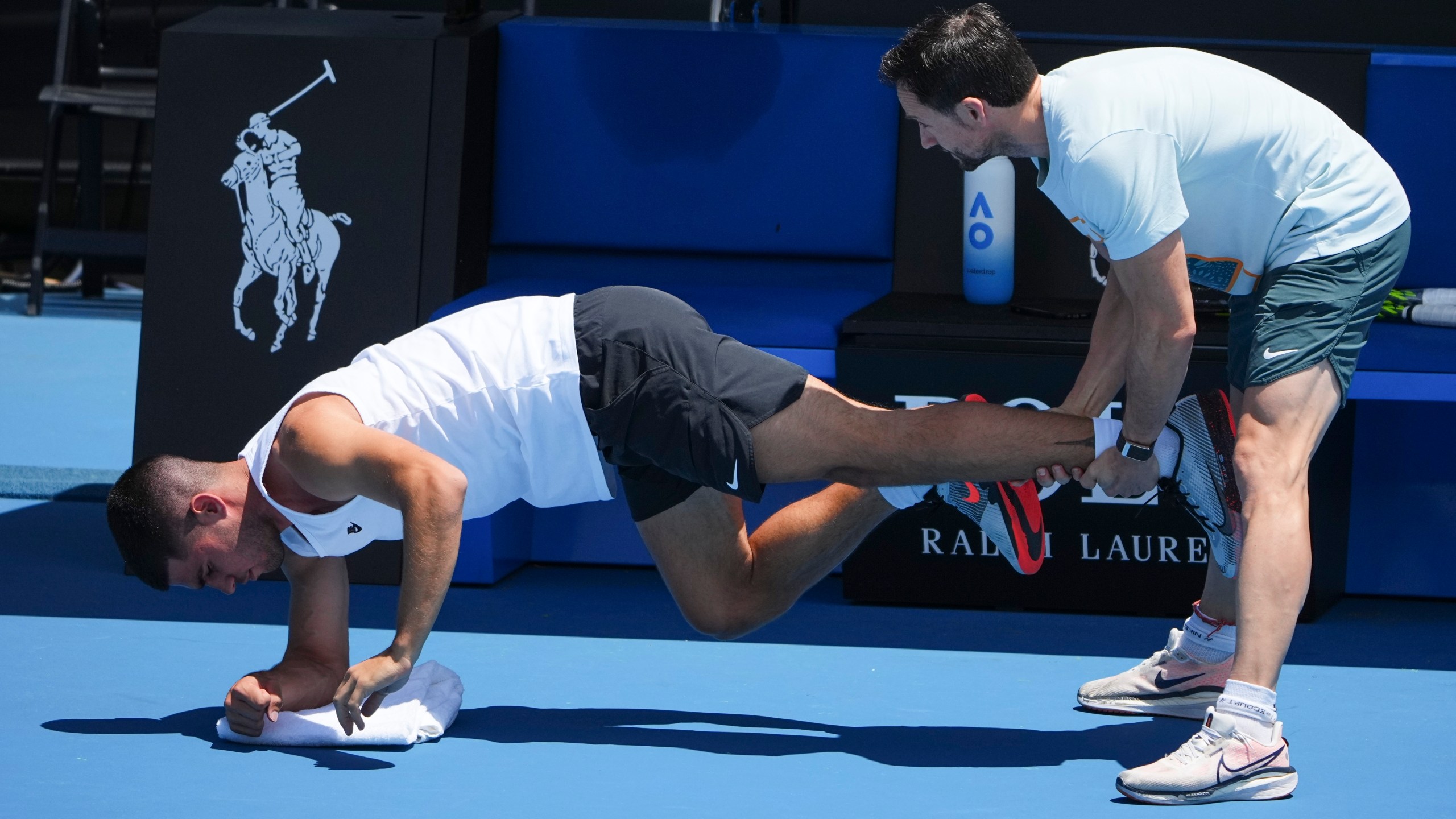 Spain's Carlos Alcaraz receives treatment from a trainer during a practice session ahead of the Australian Open tennis championship in Melbourne, Australia, Friday, Jan. 10, 2025. (AP Photo/Vincent Thian)