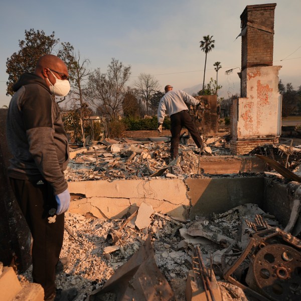 Kenneth Snowden, left, surveys the damage to his fire-ravaged property with his brother Ronnie in the aftermath of the Eaton Fire Friday, Jan. 10, 2025 in Altadena, Calif. (AP Photo/Jae C. Hong)