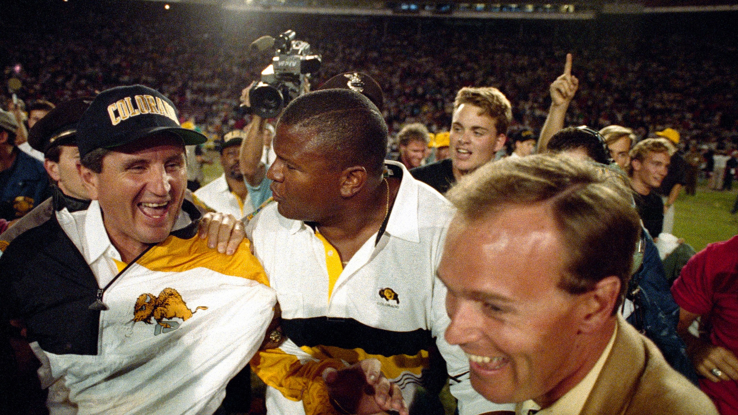 FILE - Colorado coach Bill McCartney, left, is escorted off the Orange Bowl field after the Buffaloes defeated Notre Dame, 10-9, in the 57th annual Orange Bowl Classic in Miami, Jan. 1, 1991. (AP Photo/Ray Fairall, File)