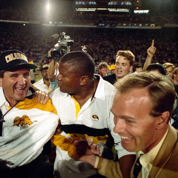 FILE - Colorado coach Bill McCartney, left, is escorted off the Orange Bowl field after the Buffaloes defeated Notre Dame, 10-9, in the 57th annual Orange Bowl Classic in Miami, Jan. 1, 1991. (AP Photo/Ray Fairall, File)