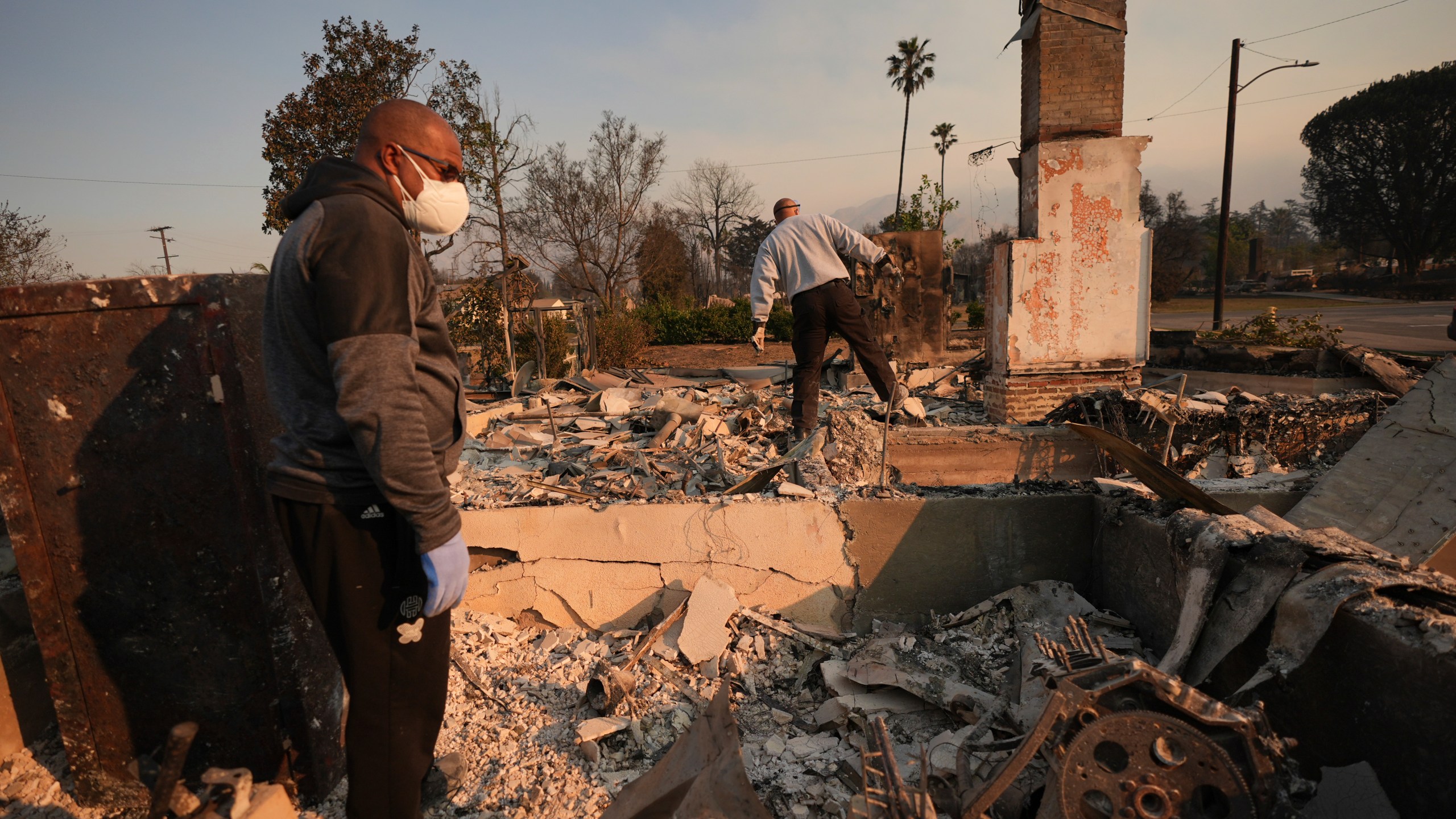 Kenneth Snowden, left, surveys the damage to his fire-ravaged property with his brother Ronnie in the aftermath of the Eaton Fire Friday, Jan. 10, 2025 in Altadena, Calif. (AP Photo/Jae C. Hong)