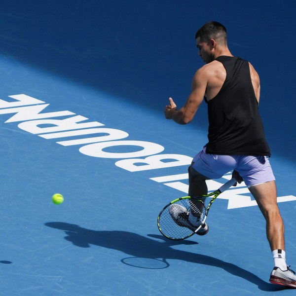 Spain's Carlos Alcaraz plays a shot between his legs during a practice session ahead of the Australian Open tennis championship in Melbourne, Australia, Thursday, Jan. 9, 2025. (AP Photo/Mark Baker)