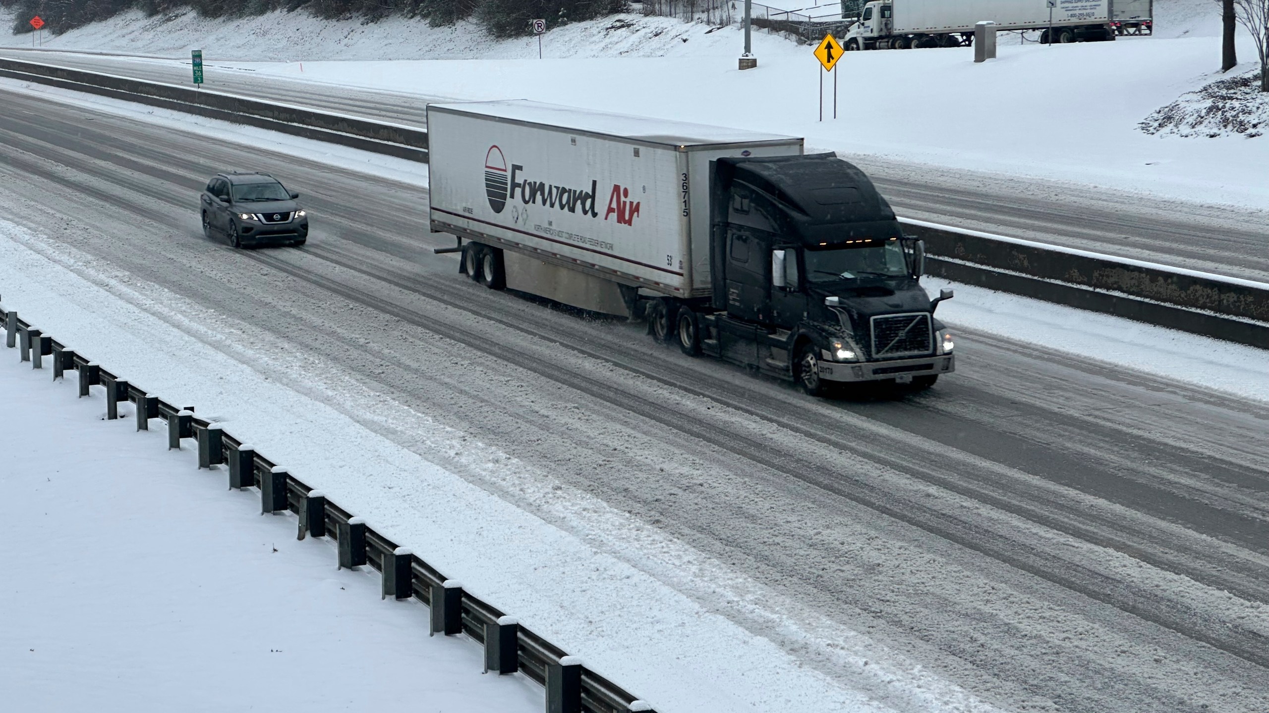 /// A truck picks its way along a slushy Interstate 285 northeast of downtown in Atlanta on Friday, Jan. 10, 2025. (AP Photo/Jeff Amy)