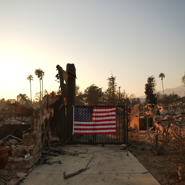 An American flag hangs on the gate of a home destroyed by the Eaton Fire in Altadena, Calif., Friday, Jan. 10, 2025. (AP Photo/Jae C. Hong)