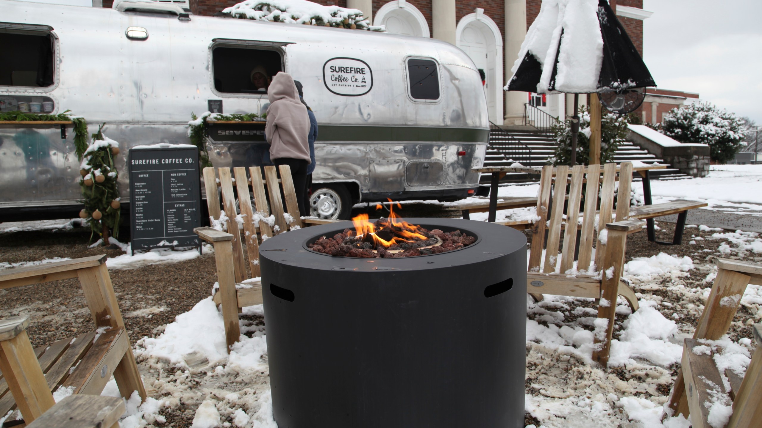 CORRECTS NAME OF RESTAURANT - People drink coffee outside of Surefire Coffee Co. after snow fell in the area in Nashville, Tenn. on Saturday, Jan.11, 2025. (AP Photo/Kristin M. Hall)