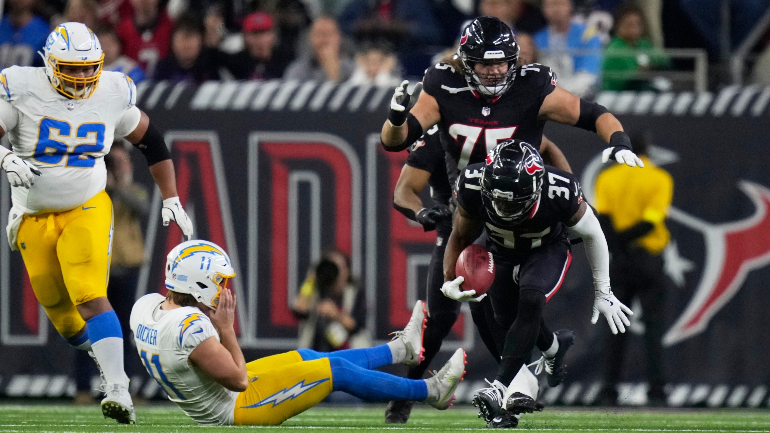 Houston Texans' D'Angelo Ross (37) returns a blocked extra-point attempt by Los Angeles Chargers place kicker Cameron Dicker (11) for two-points during the second half of an NFL wild-card playoff football game Saturday, Jan. 11, 2025, in Houston. (AP Photo/Eric Christian Smith)