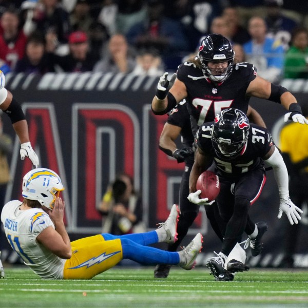 Houston Texans' D'Angelo Ross (37) returns a blocked extra-point attempt by Los Angeles Chargers place kicker Cameron Dicker (11) for two-points during the second half of an NFL wild-card playoff football game Saturday, Jan. 11, 2025, in Houston. (AP Photo/Eric Christian Smith)