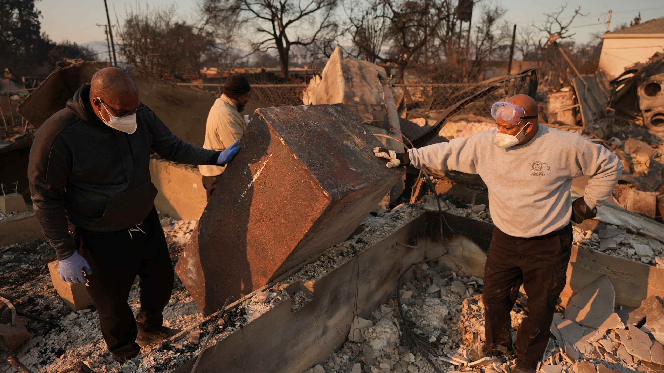 Kenneth Snowden, left, surveys the damage to his fire-ravaged property with his brother Kim, center, and Ronnie in the aftermath of the Eaton Fire Friday, Jan. 10, 2025 in Altadena, Calif. (AP Photo/Jae C. Hong)