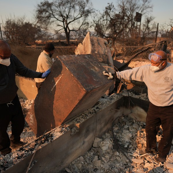 Kenneth Snowden, left, surveys the damage to his fire-ravaged property with his brother Kim, center, and Ronnie in the aftermath of the Eaton Fire Friday, Jan. 10, 2025 in Altadena, Calif. (AP Photo/Jae C. Hong)