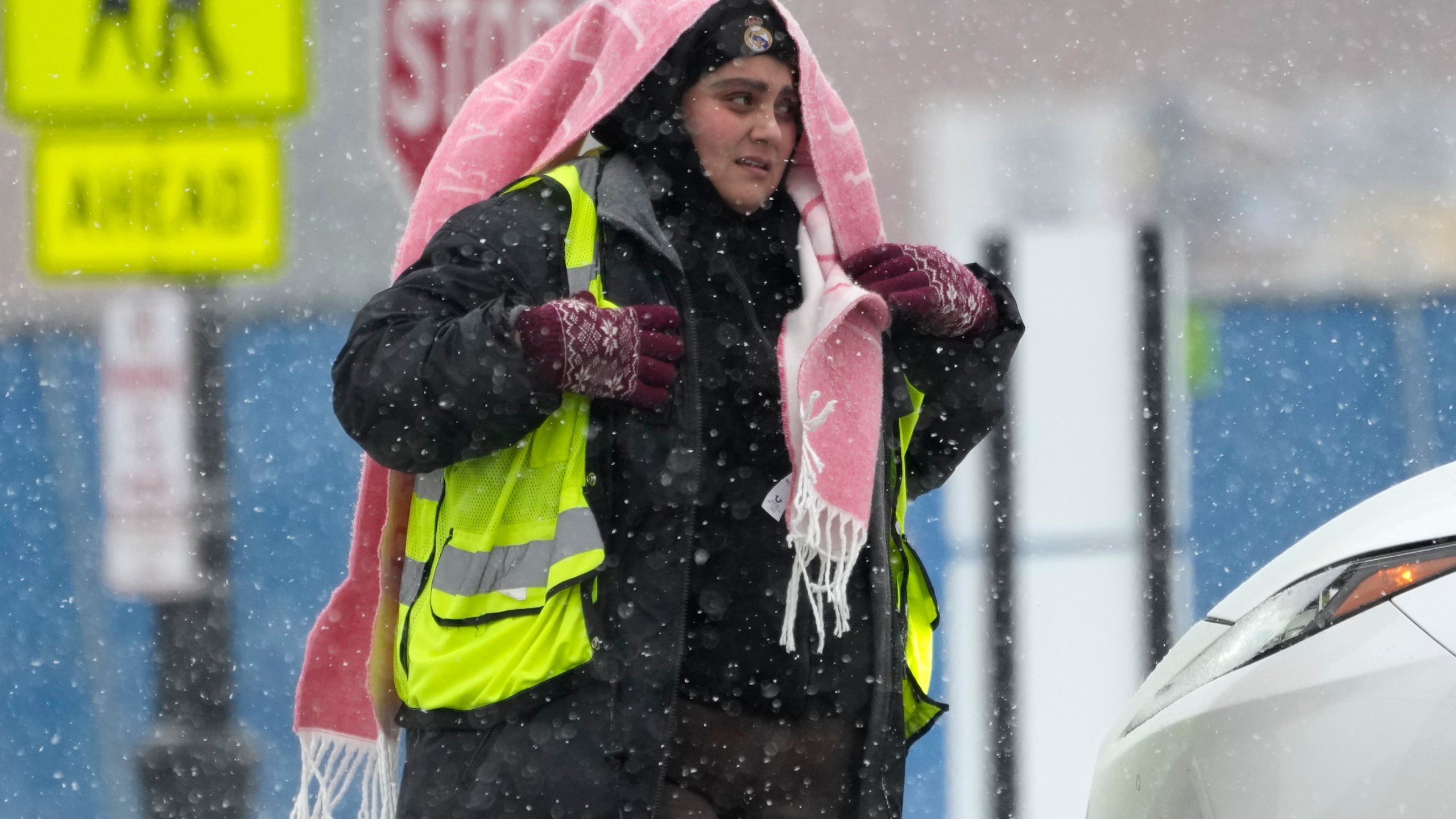 A parking attendant waits to help drivers at a Northwestern University parking lot during a snow day in Evanston, Ill., Sunday, Jan. 12, 2025. (AP Photo/Nam Y. Huh)