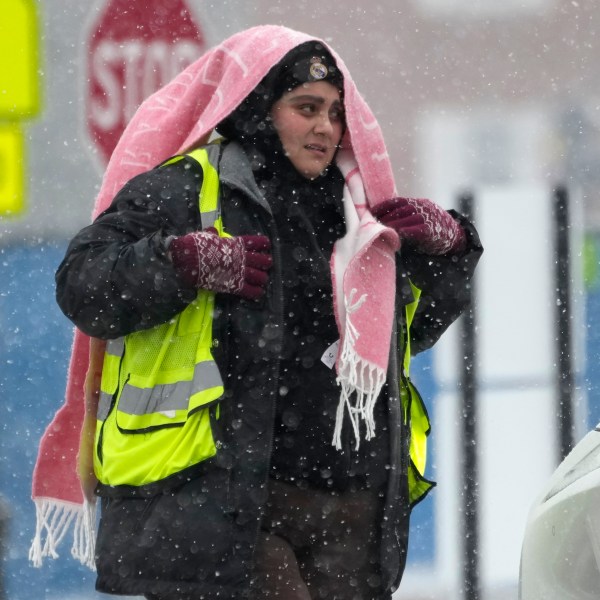 A parking attendant waits to help drivers at a Northwestern University parking lot during a snow day in Evanston, Ill., Sunday, Jan. 12, 2025. (AP Photo/Nam Y. Huh)