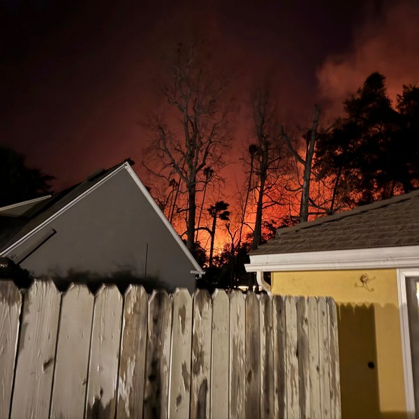 The Eaton wildfire approaches the yellow home of the Prata family in Altadena, California, the night of Tuesday, Jan. 7, 2025. (AP Photo/Vanessa Prata)