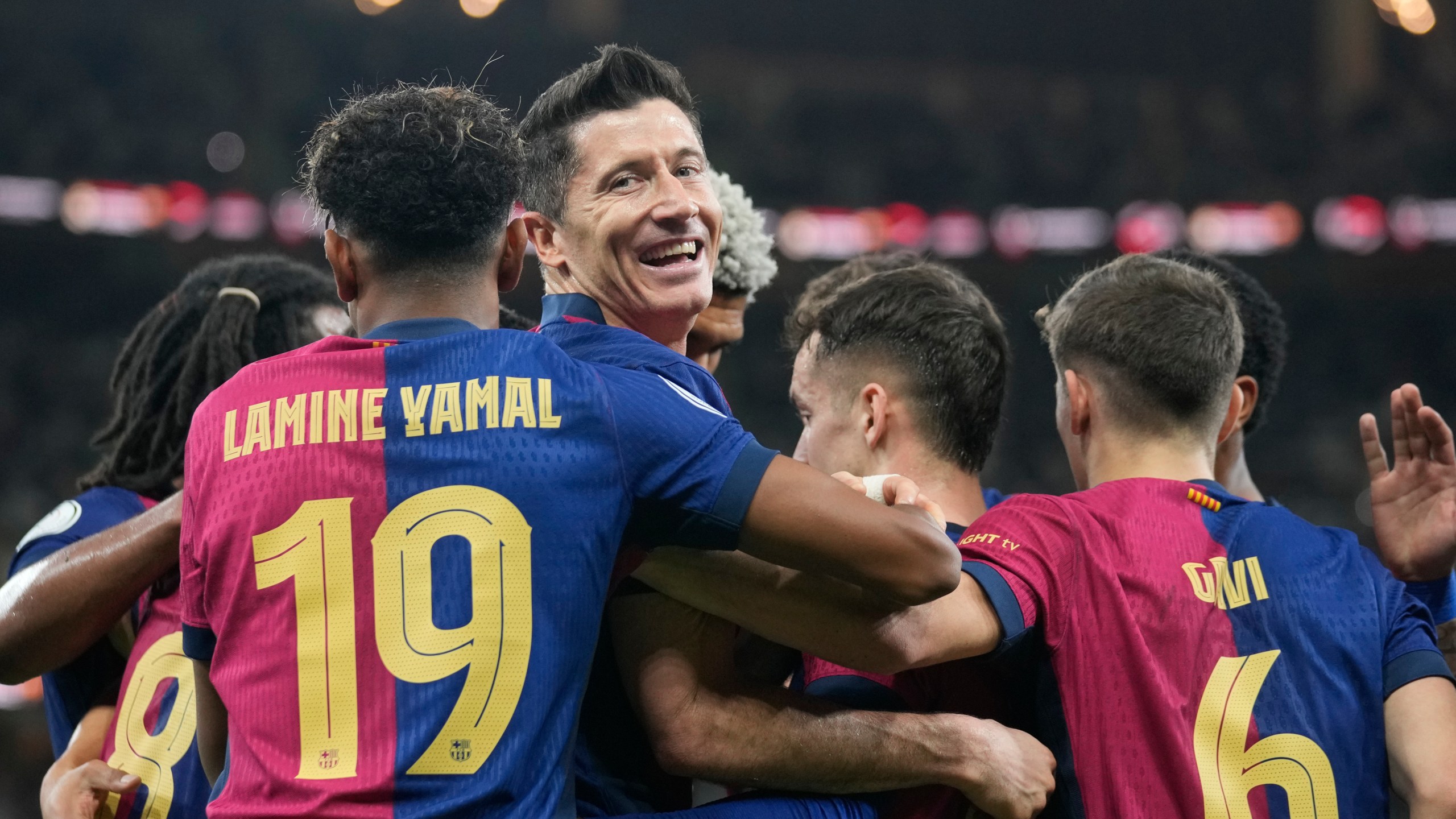 Barcelona's Robert Lewandowski, centre, celebrates after scoring his side's second goal during the Spain Super Cup final soccer match between Real Madrid and Barcelona at King Abdullah Stadium in Jeddah, Saudi Arabia, Sunday, Jan. 12, 2025. (AP Photo/Altaf Qadri)