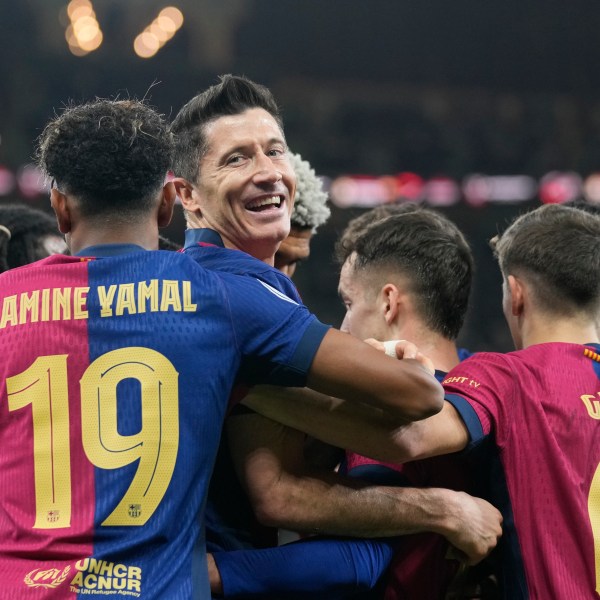 Barcelona's Robert Lewandowski, centre, celebrates after scoring his side's second goal during the Spain Super Cup final soccer match between Real Madrid and Barcelona at King Abdullah Stadium in Jeddah, Saudi Arabia, Sunday, Jan. 12, 2025. (AP Photo/Altaf Qadri)