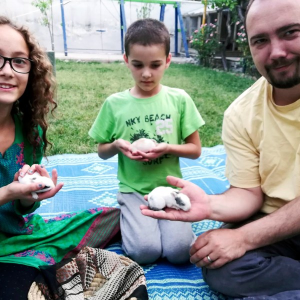 This family photo shows Ryan Corbett holding rabbits with his daughter Miriam and son Caleb in Kabul, Afghanistan in 2020. (AP Photo/Anna Corbett)