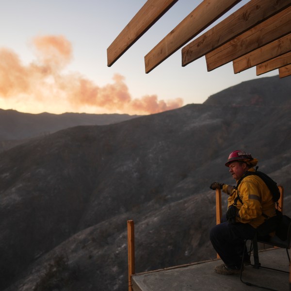 A firefighter rests as crews battle the Palisades Fire in Mandeville Canyon, Saturday, Jan. 11, 2025, in Los Angeles. (AP Photo/Eric Thayer)