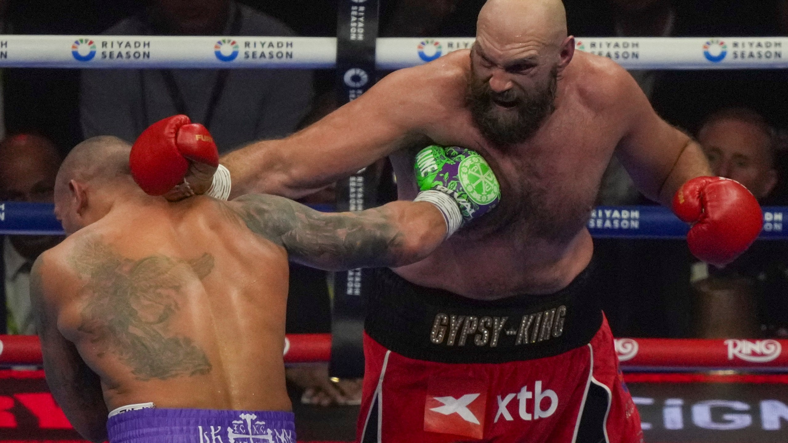 Boxers Britain's Tyson Fury, right, and Ukraine's Oleksandr Usyk compete during their WBA, WBO, and WBC world heavyweight title fight in Riyadh, Saudi Arabia, Saturday, Dec. 21, 2024. (AP Photo/Frank Augstein)