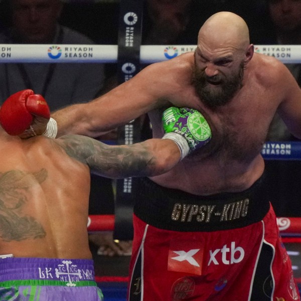 Boxers Britain's Tyson Fury, right, and Ukraine's Oleksandr Usyk compete during their WBA, WBO, and WBC world heavyweight title fight in Riyadh, Saudi Arabia, Saturday, Dec. 21, 2024. (AP Photo/Frank Augstein)