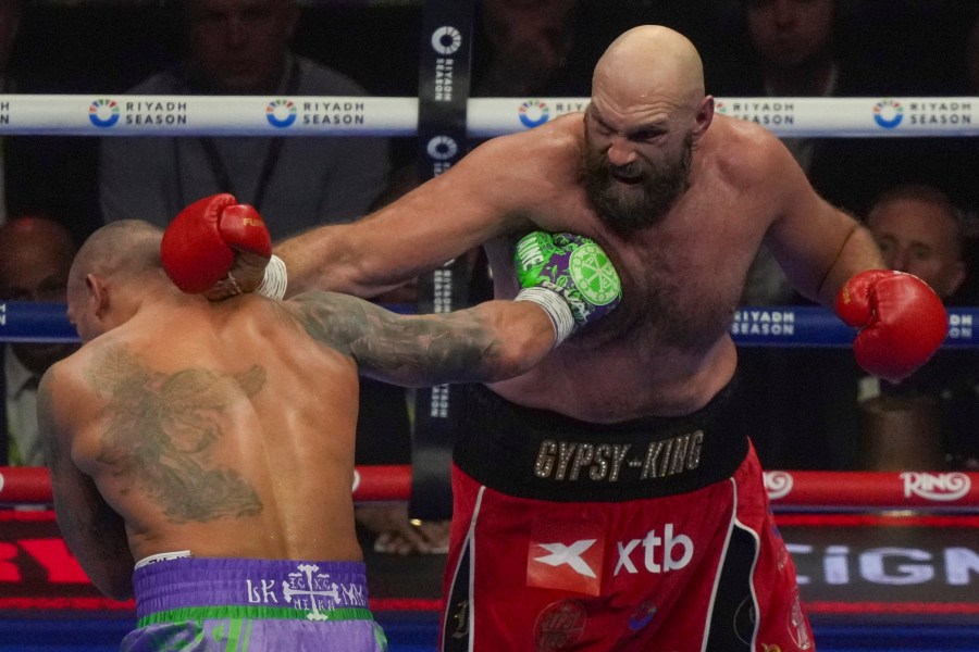 Boxers Britain's Tyson Fury, right, and Ukraine's Oleksandr Usyk compete during their WBA, WBO, and WBC world heavyweight title fight in Riyadh, Saudi Arabia, Saturday, Dec. 21, 2024. (AP Photo/Frank Augstein)