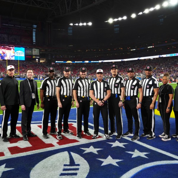 Officials including side judge Eugene Hall; side judge Allen Baynes; back judge Tony Josselyn; referee John Hussey; down judge Dana McKenzie; back judge Matt Edwards and umpire Terry Killens pose before an NFL wild card playoff football game between the Los Angeles Rams and Minnesota Vikings, Monday, Jan. 13, 2025, in Glendale, Ariz. (AP Photo/Ross D. Franklin)