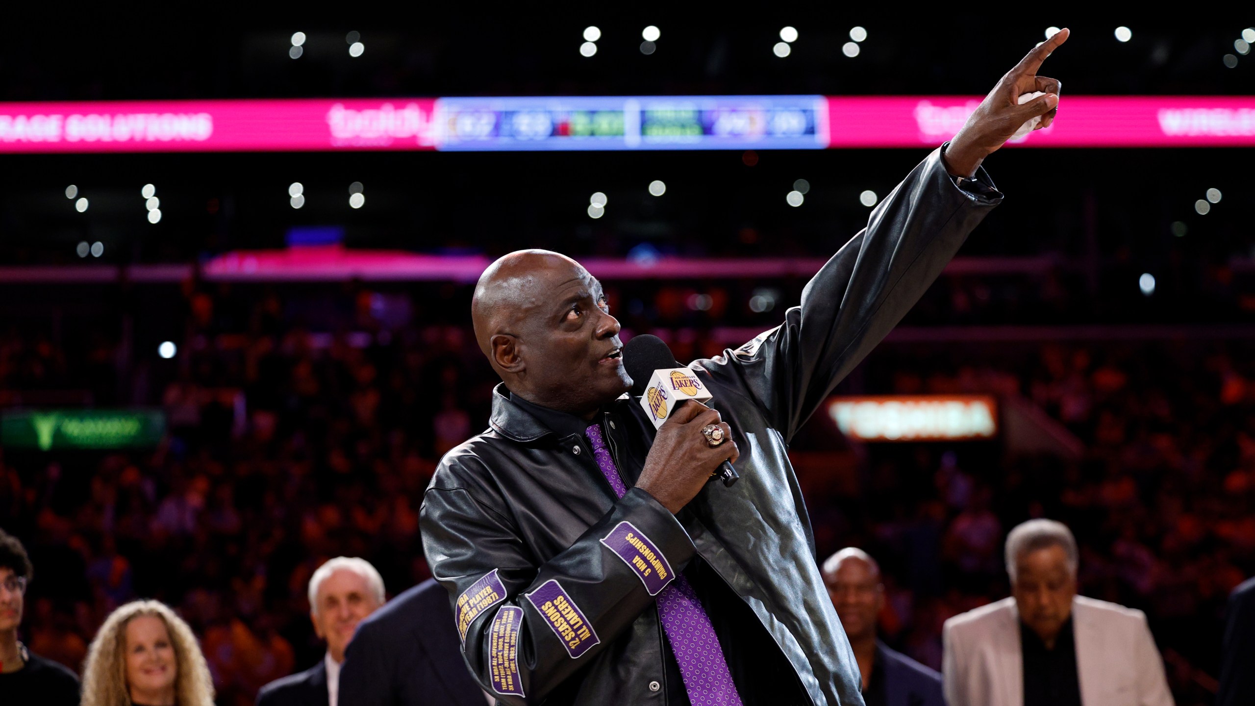 Former Los Angeles Lakers player Michel Cooper, center, gestures during his jersey retirement ceremony during halftime in a NBA basketball game between the Los Angeles Lakers and the San Antonio Spurs, Monday, Jan. 13, 2025, in Los Angeles. (AP Photo/Kevork Djansezian)