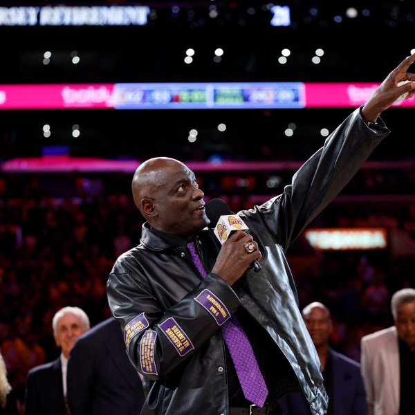 Former Los Angeles Lakers player Michel Cooper, center, gestures during his jersey retirement ceremony during halftime in a NBA basketball game between the Los Angeles Lakers and the San Antonio Spurs, Monday, Jan. 13, 2025, in Los Angeles. (AP Photo/Kevork Djansezian)