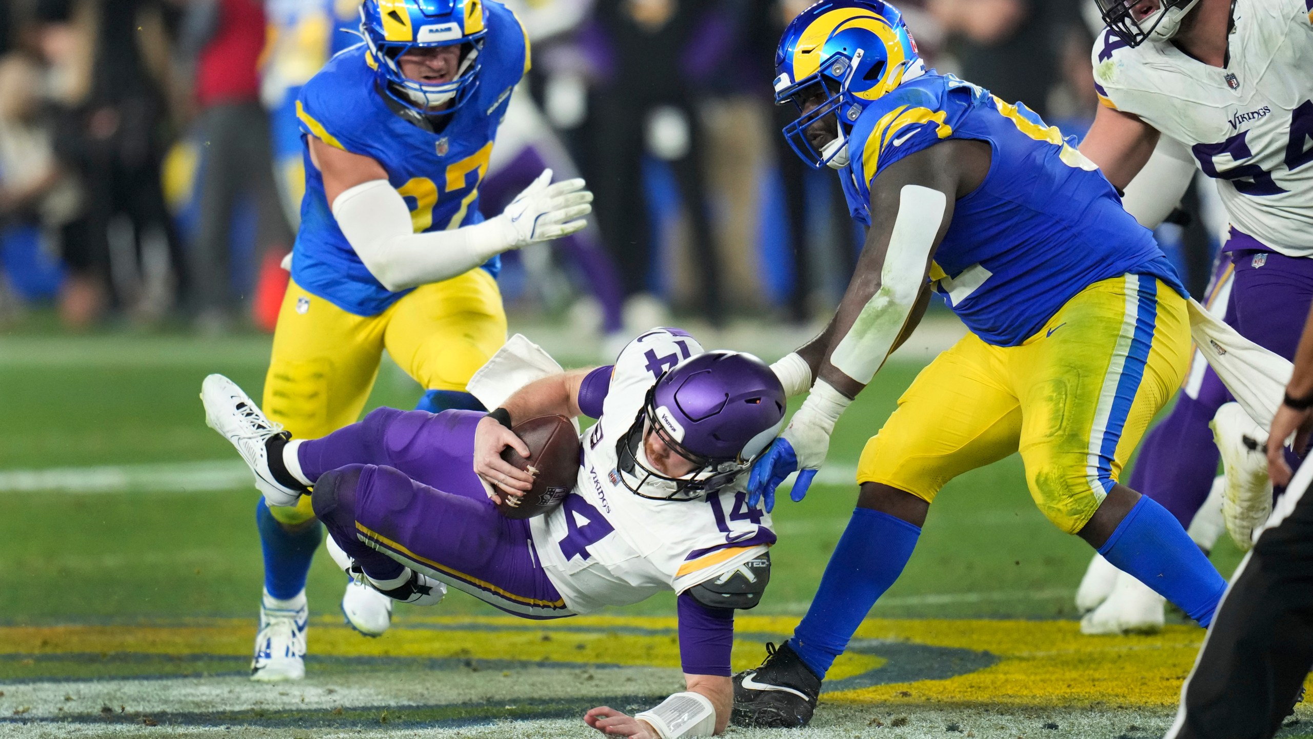 Los Angeles Rams defensive tackle Neville Gallimore (92) sacks Minnesota Vikings quarterback Sam Darnold (14) during the second half of an NFL wild card playoff football game, Monday, Jan. 13, 2025, in Glendale, Ariz. (AP Photo/Ross D. Franklin)