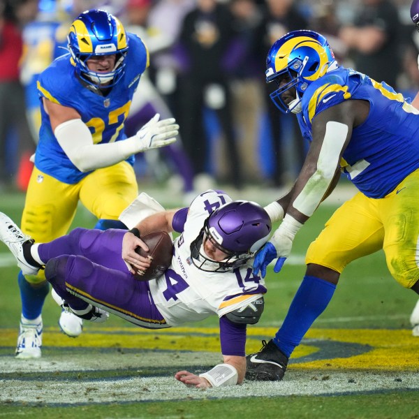 Los Angeles Rams defensive tackle Neville Gallimore (92) sacks Minnesota Vikings quarterback Sam Darnold (14) during the second half of an NFL wild card playoff football game, Monday, Jan. 13, 2025, in Glendale, Ariz. (AP Photo/Ross D. Franklin)