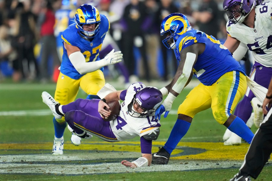 Los Angeles Rams defensive tackle Neville Gallimore (92) sacks Minnesota Vikings quarterback Sam Darnold (14) during the second half of an NFL wild card playoff football game, Monday, Jan. 13, 2025, in Glendale, Ariz. (AP Photo/Ross D. Franklin)