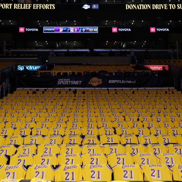 Jerseys with the number of former Los Angeles Lakers player Michel Cooper are left for fans on seats before an NBA basketball game between the Lakers and the San Antonio Spurs, Monday, Jan. 13, 2025, in Los Angeles. Cooper's No. 21 jersey will be raised into the rafters during halftime. (AP Photo/Kevork Djansezian)